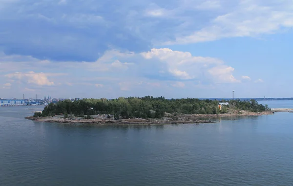 A medium-sized rocky island, covered with trees, off the coast o — Stock Photo, Image