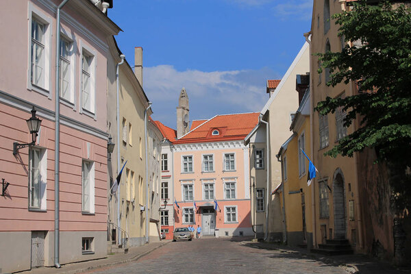 Tallinn, Estonia / June 23, 2019: Street of Old Tallinn. Medieval houses, facades. On one house are Estonian and Finnish flags.