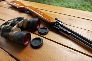 Dürbün bir masada bir tüfek yanında döşeme