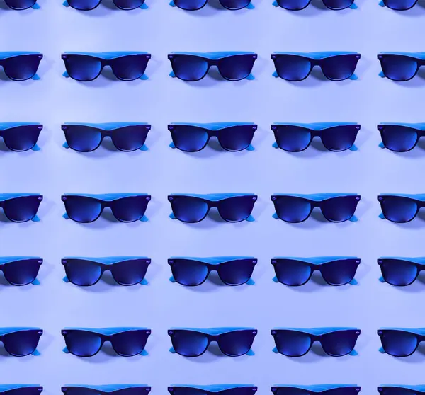 Viele Paar blaue Sonnenbrillen auf einer ebenen Fläche — Stockfoto