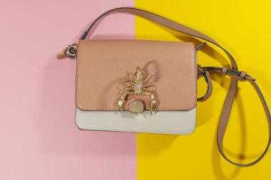 Bir cüzdan pembe ve sarı bir yüzeyin ortasında