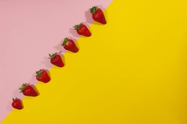 Pembe ve sarı yüzeyde bir çilek çizgisi