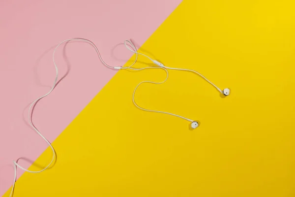 Headphones laying on a yellow and pink surface — Stock Photo, Image