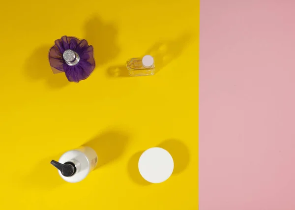 Flaschen stehen auf einer rosa und gelben Oberfläche — Stockfoto