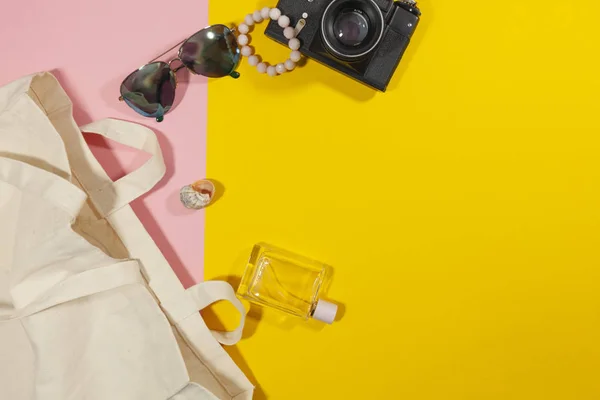 Varios objetos yacen sobre una superficie rosa y amarilla — Foto de Stock