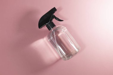 Pembe arka plan üzerine koyulan berrak bir şişe