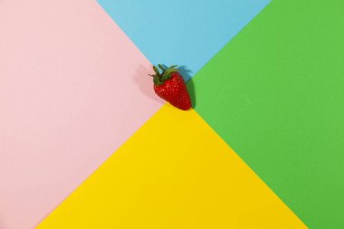 Bir çilek düz bir yüzeyüzerinde yatıyor