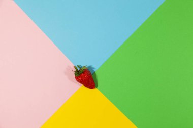 Bir çilek düz bir yüzeyüzerinde yatıyor