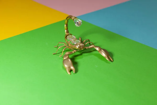 Goldminiatur-Skorpion steht auf einer ebenen Oberfläche — Stockfoto