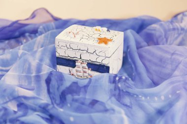 Suya benzeyen mavi bir malzemenin üzerine serpiştirilen beyaz ve mavi bir kutu