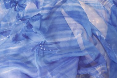 Beyaz benekli mavi bir malzeme kırışık yatıyor.