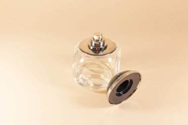 Pembe bir yüzeye serpiştirilen berrak bir cam şişe