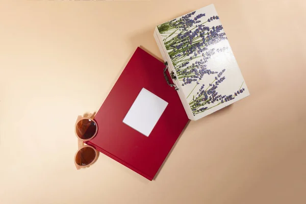 Ett rött kuvert, en vit låda och solglasögon lägger på en rosa yta — Stockfoto