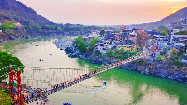 Ganj Nehri 'nin tepesindeki ünlü köprü Laxman Jhula' nın etrafı tapınak ve dağlarla çevrili.