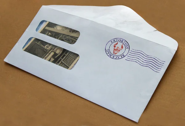 An envelope with photos and postal stamp illustrating the concept of blackmail for extortion