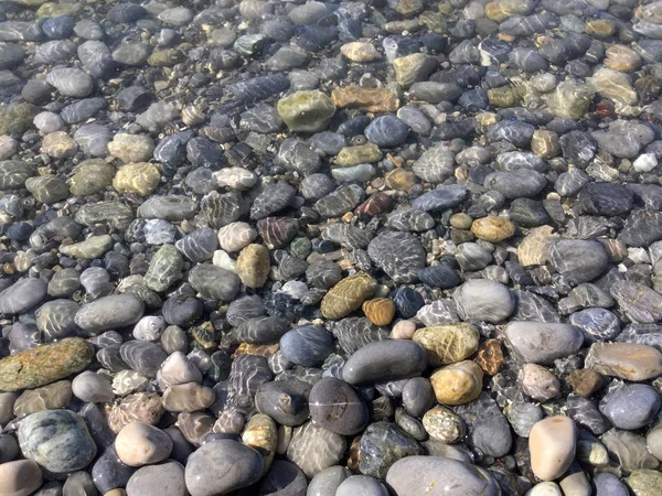 The image of water ripples over the pebbles, the sea water with — Stock Photo, Image