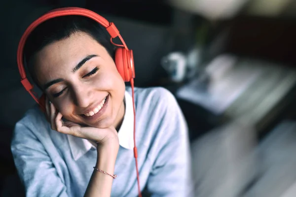 kırmızı kulaklık ile müzik dinlemutlu genç kadın