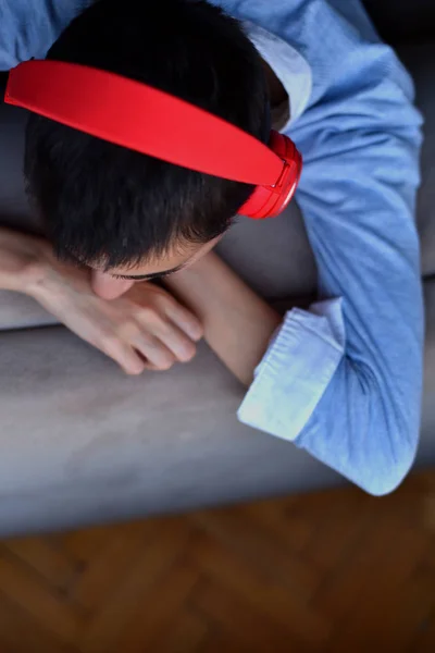 Kırmızı kulaklıklı genç bayan evde müzik dinlemeye hazırlanıyor.