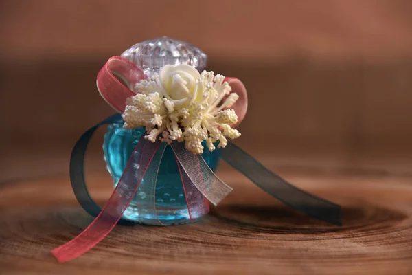 cam şişe içinde parfüm ve çiçek ile dekore