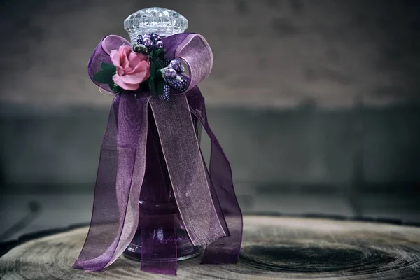 çiçek ve kurdele ile süslenmiş cam şişe parfüm