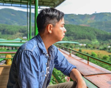 Genç bir adam rahatlatıcı dağ manzaralı kahve dükkanında Dalat, orta Highland, Vietnam.