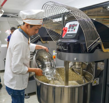 Saigon, Vietnam - 9 Ocak 2019. Saigon, Vietnam fabrikasında makine karıştırma un kullanarak ekmek işlemini.