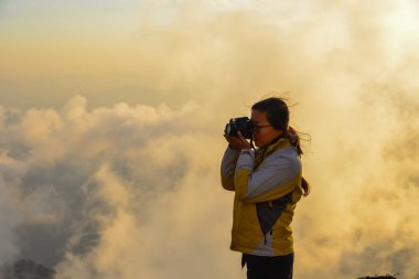 Dağ üzerinde duran ve Annapurna Massif (Nepal) doruklarına kar sunrise keyfini bir genç kadın backpacker.