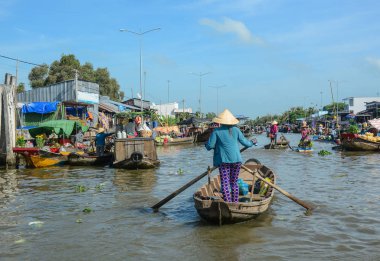 Mekong Delta, Vietnam - Feb 2, 2016. A woman rowing wooden boat at Nga Nam floating market in Mekong Delta, Vietnam. clipart