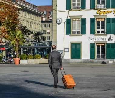 Bern, İsviçre - 22 Ekim 2018. Bern, İsviçre için şehrin eski sokakta yürüme zarif çanta olan bir adam. Bern İsviçre fiili başkentidir.