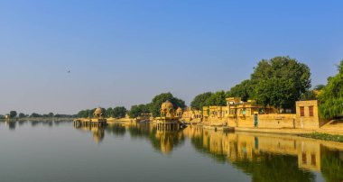 Gadsisar göl güneşli bir günde Jaisalmer, Hindistan, antik Hindu tapınakları ile.