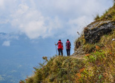 Dağda bir çift ayakta ve manzaraya bakarak.