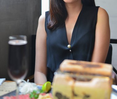 Zarif Asyalı genç kadın Japon lokantasında otururken.