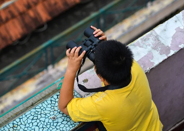 Un chico asiático usando el binocular — Foto de Stock