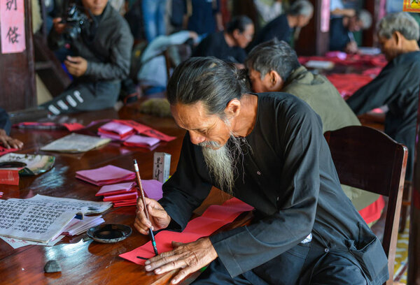 Writing chinese calligraphy on red paper 