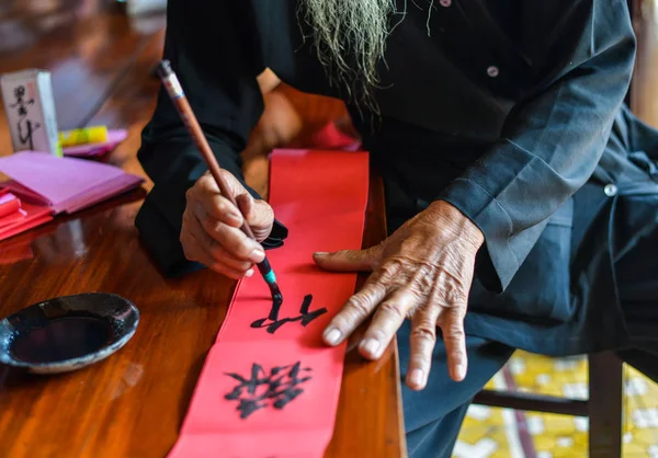 Menulis kaligrafi Cina pada kertas merah — Stok Foto