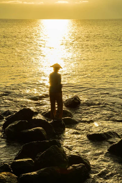Ein Mann angelt am Strand bei Sonnenuntergang — Stockfoto
