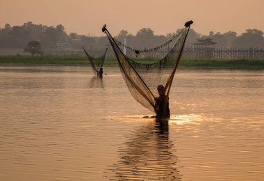 Gün doğumunda gölde balık yakalamak 