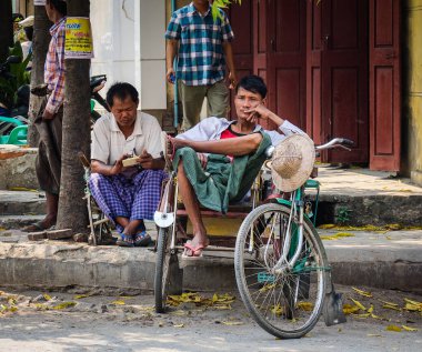 Rickshaw sürücüleri sokakta bekliyor 