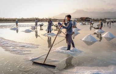 Nha Trang, Vietnam - 21. Nha Trang, Vietnam'da gün doğumunda tuz sahasında çalışan insanlar. Tuz alanları Nha Trang en eşsiz yerlerinden biridir.