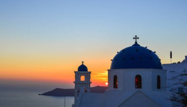 Santorini Adası'nda gün batımında Antik Yunan Ortodoks kilisesi. Santorini dünyanın en popüler adalarından biridir.