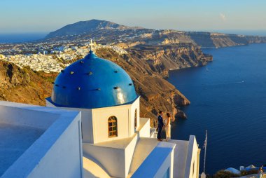Santorini, Yunanistan - 4 Ekim 2018. Santorini Adası'ndaki Ortodoks kilisesinde duran tatlı bir çift. Santorini dünyanın en popüler adalarından biridir.