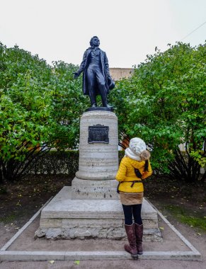 St. Petersburg, Rusya - 13 Ekim 2016. St. Petersburg'daki Puşkin Heykeli'ni ziyaret eden bir kadın. Puşkin Rusya'da önemli bir etkisi olan büyük bir şair.