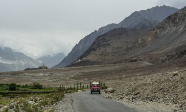 Ladakh, Hindistan - 18 Temmuz 2015. Ladakh, Hindistan'da dağ yolunda bir araba. Ladakh, Jammu & Keşmir eyaletinin en yüksek platosudur ve büyük bir kısmı 3000 metrenin üzerindedir..