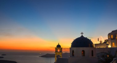 Santorini Adası'nda gün batımında Antik Yunan Ortodoks kilisesi. Santorini dünyanın en popüler adalarından biridir.