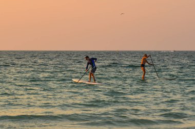 Dubai, Bae - 7 Aralık 2018. Dubai, Bae'de gün batımında Burj Al Arab Hotel yakınlarında denizde kanoyla binen turistler.