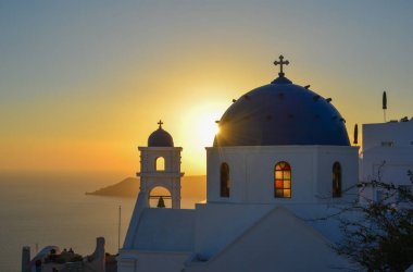Santorini Adası'nda gün batımında Antik Yunan Ortodoks kilisesi. Santorini dünyanın en popüler adalarından biridir.