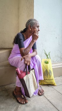Galle, Sri Lanka - 9 Eylül 2015. Galle, Sri Lanka'da sokak pazarında oturan ve bekleyen yaşlı bir kadın.