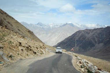 Ladakh, Hindistan - 18 Temmuz 2015. Ladakh, Hindistan'da dağ yolunda bir araba. Ladakh, Jammu & Keşmir eyaletinin en yüksek platosudur ve büyük bir kısmı 3000 metrenin üzerindedir..