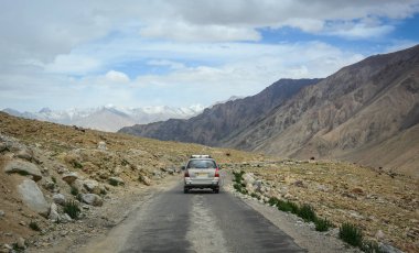 Ladakh, Hindistan - 18 Temmuz 2015. Ladakh, Hindistan'da dağ yolunda bir araba. Ladakh, Jammu & Keşmir eyaletinin en yüksek platosudur ve büyük bir kısmı 3000 metrenin üzerindedir..