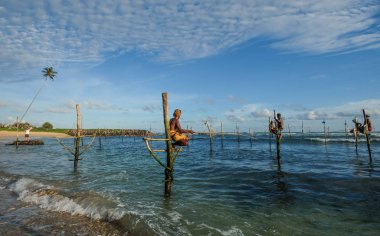 Hikkaduwa, Sri Lanka - 9 Eylül 2015. Hikkaduwa, Sri Lanka güneşli bir günde plajda benzersiz bir tarzda balıkçılık Yerel balıkçılar.